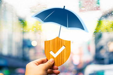 Traveler holding insurance symbol with check mark and umbrella icon on top with rainy Chinatown in...
