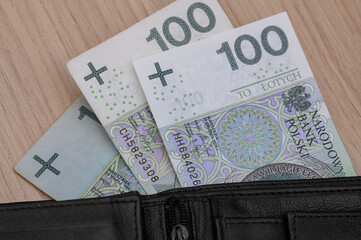 Polish currency, 100 złoty banknotes stick out from the wallet