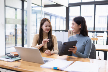 Two Asian young businesswoman using laptop computer working in office,