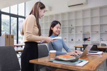 Two Asian young businesswoman using laptop computer working in office,