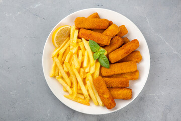 Fish and chips .Close up of crispy breaded deep fried fish fingers with breadcrumbs served with remoulade sauce and lemon