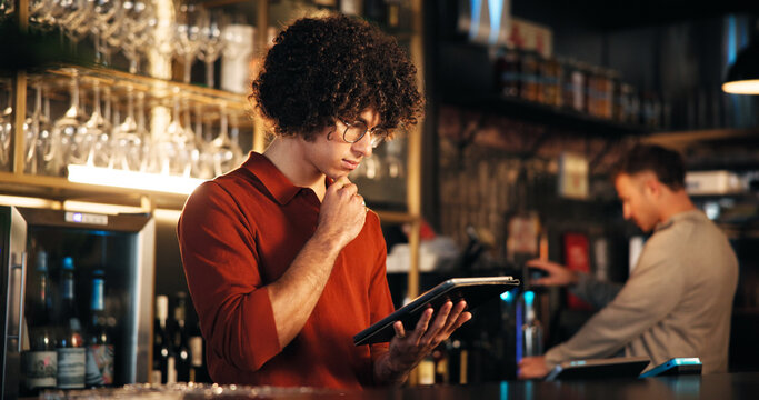 Pub manager, man and thinking with tablet for sales report, inventory checklist and menu review. Small business, bartender and digital app in restaurant for supplier management and online stock order - Powered by Adobe