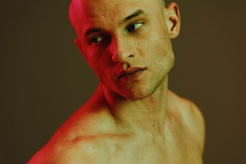 Artistic portrait of a pensive man with striking lighting, featuring a captivating interplay of red...