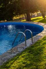 Sparkling swimming pool framed by lush green grass in a sunlit setting