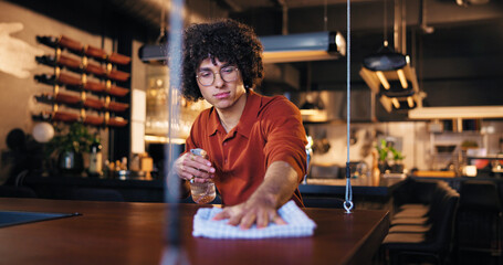 Cleaning, waiter and man with spray, bar and chemical for hygiene, routine and sanitation for...