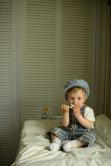 Festively dressed baby sitting on a changing table and playing with a toy at home. Adorable...