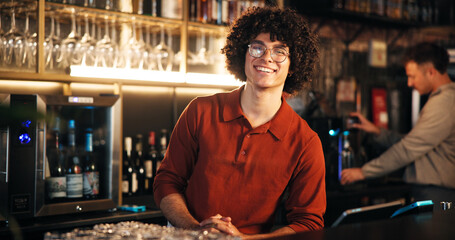 Smile, man and bartender at counter in pub for friendly welcome, customer service and hospitality....