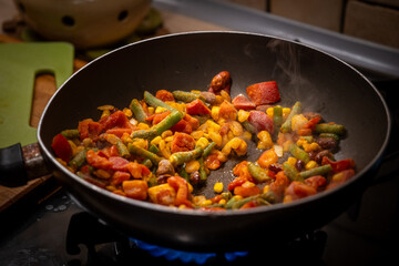 Preparing a healthy, balanced meal: frying frozen vegetables and chicken in a pan. Nutritious cooking, clean eating, and wholesome diet concept for a healthy lifestyle