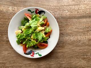 Closeup shot of fresh home made vegetable salad on wooden table
