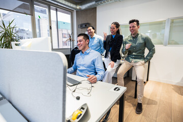 Excited businesspeople celebrating achieving goals, closing a deal, or receiving good news while...