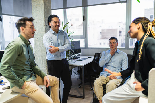 Business colleagues engaging in a productive discussion, fostering teamwork and innovation in a contemporary office environment - Powered by Adobe