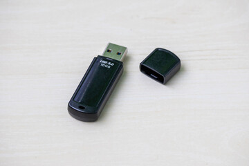 High-speed black 16GB USB 3.0 pendrive showcased on a pale wood background, perfect for tech,...