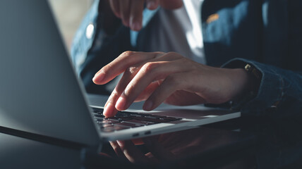 Closeup, business woman hands working and typing on laptop keyboard on glass table. Woman...