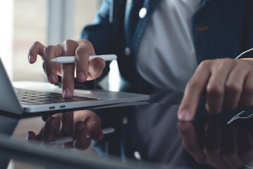 Closeup, business woman hands working on laptop and using digital tablet, surfing the internet on...