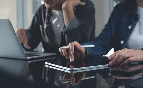 Business team brainstorming in modern office. Asian business colleague together working on laptop computer and digital tablet on office table, planning and researching process