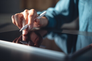 Closeup, woman hand with stylus pen using digital tablet, finger touching on tablet screen. Surfing...