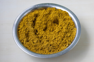 Homemade coriander powder in a traditional steel plate, natural dried spice for Indian cuisine and global dishes, rich texture.
