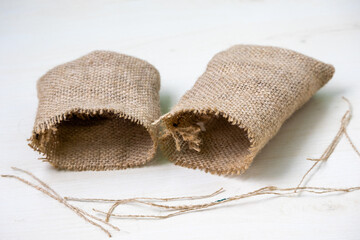 Small empty brown jute bags on white background. Isolated textile sacks, natural packaging, rustic storage, agriculture, eco-friendly. Perfect for product mockups and design.