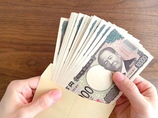茶封筒に入った紙幣を取り出す手