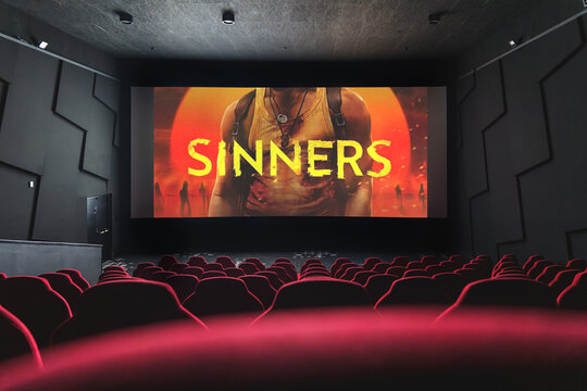 Sinners movie playing in empty cinema, action and horror film on big screen.