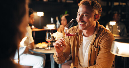 Happy man, night and drinking with wine in restaurant for fine dining, dinner or anniversary in...