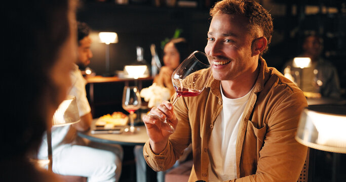 Happy man, night and drinking with wine in restaurant for fine dining, dinner or anniversary in cafe. Male person, alcohol and glass with couple on date for romance, valentines day or evening out