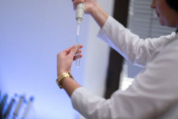 Scientist using pipette in laboratory experiment