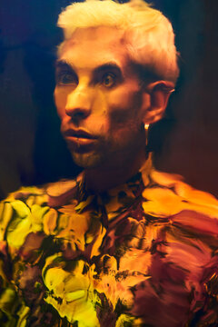 Distorted reflection of an astonished young guy on dichroic film