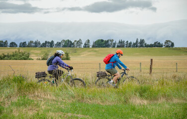 Two young people cycling Otago Central Rail Trail. South Island. New Zealand.