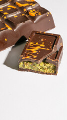 Dark Dubai chocolate bar with vibrant turmeric speckles and hidden pistachio core, crafted for World Chocolate Day and Diwali delights
