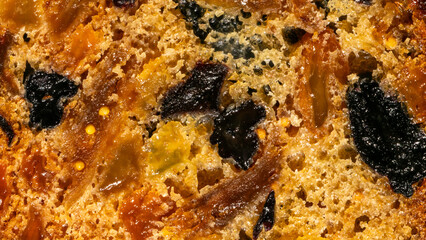 Golden-brown fruitcake texture, spiced whispers of Yule traditions, vibrant morsels nestled like...