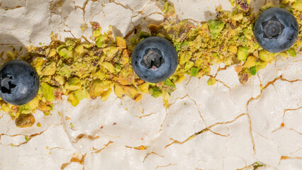 Blueberries and pistachios atop cracked meringue evoke a sweet symphony, perfect for Pistachio Day...