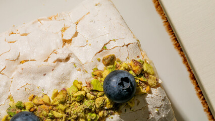 Crackled meringue whispers pistachio secrets with bold blueberry dreams; celebrate Pistachio Day and culinary art nuances