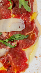 Delicate carpaccio with emerald arugula, celebrating Italian Ferragosto and National Cheese Day,...