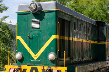 Green locomotive gleams in sunlight, evoking industrial nostalgia, capturing spirit of Train Day, echoes of forgotten rail adventures  Šarganska (sharganska) osmica