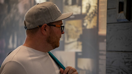 A contemplative Caucasian man in an art gallery admires urban surrealism, embodying World Art Day's...