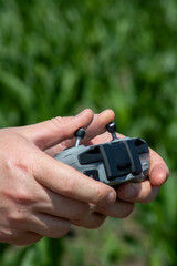 Hands gently cradling a drone controller amid lush greenery, invoking nature's watchful eye, Earth Day innovation synergy