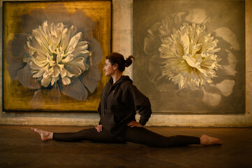 Young woman practicing yoga poses in an art gallery space, combining wellness and creativity. Mindful lifestyle, body awareness, and harmony in modern cultural environment
