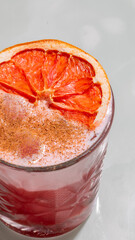 Zesty grapefruit cocktail crowned with cinnamon dust, evoking Carnival festivities, tantalizing...