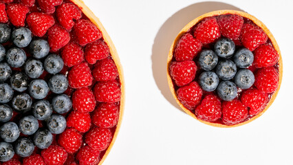 Berry-laden tarts with vivid raspberries and blueberries evoke summer solstice abundance and colorful Bastille Day festivities