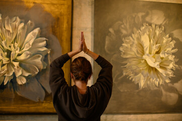 Young woman practicing yoga poses in an art gallery space, combining wellness and creativity. Mindful lifestyle, body awareness, and harmony in modern cultural environment