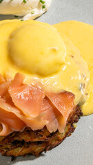 Sumptuous brunch of smoked salmon and poached egg draped in golden hollandaise, evoking World Egg...