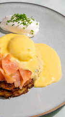 Creamy Hollandaise smothers savory latke with rosy salmon, whispering Hanukkah delight and indulgent brunch whispers in delightful harmony