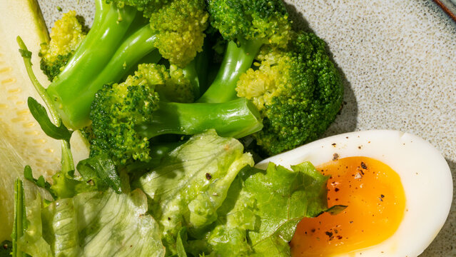 Steamed broccoli and tender boiled egg cradle in rustic harmony, World Vegetarian Day feast, nourishing verdant delight - Powered by Adobe