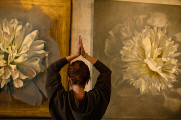 Young woman practicing yoga poses in an art gallery space, combining wellness and creativity. Mindful lifestyle, body awareness, and harmony in modern cultural environment