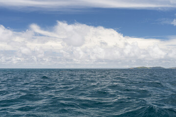 Ocean waves with turquoise water and white clouds