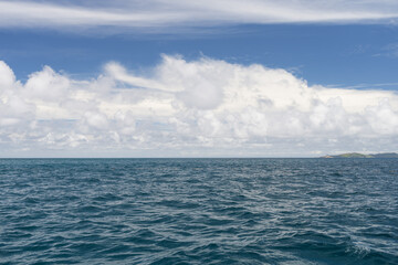 Obraz premium Ocean waves with turquoise water and white clouds