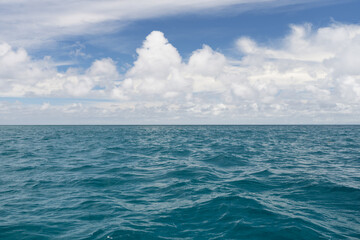 Ocean waves with turquoise water and white clouds