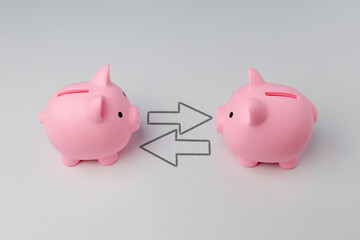 Two piggy banks with arrows indicate an exchange. Financial exchange or transfer concept.