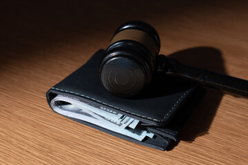Gavel on top of a wallet. Wage garnishment, fines, or financial judgments concept.